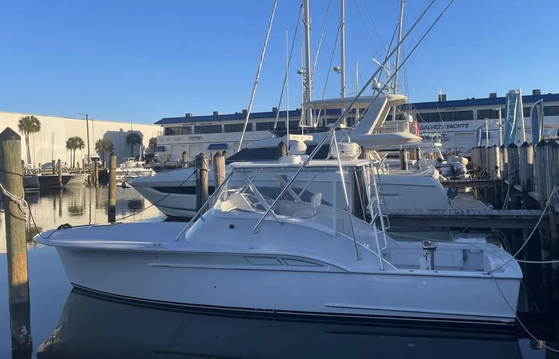 Lures & Liars Yacht Photos Pics 2002 Miller Marine Express boat docked at a marina under clear blue skies.