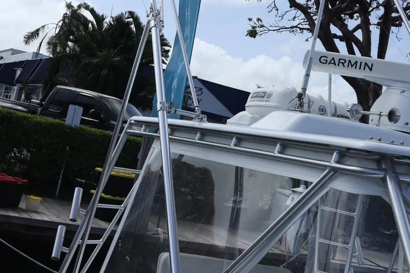 Lures & Liars Yacht Photos Pics 2002 Miller Marine Express boat docked, featuring Garmin equipment, with trees and buildings in the background.