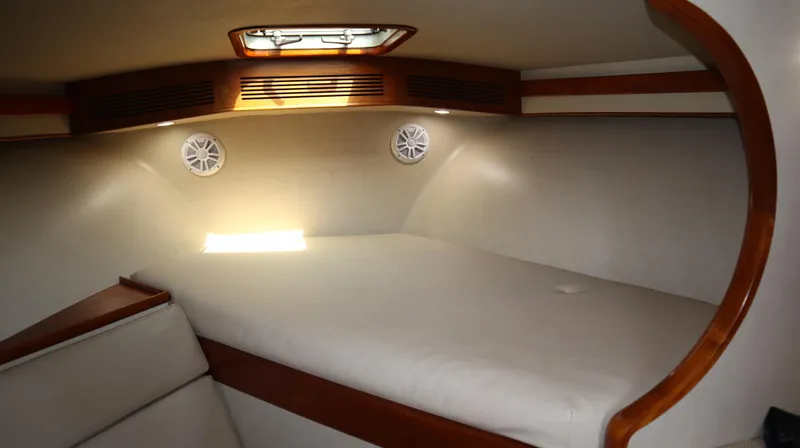 Lures & Liars Yacht Photos Pics Interior cabin of 2002 Miller Marine Express boat with cozy bed and wooden accents.