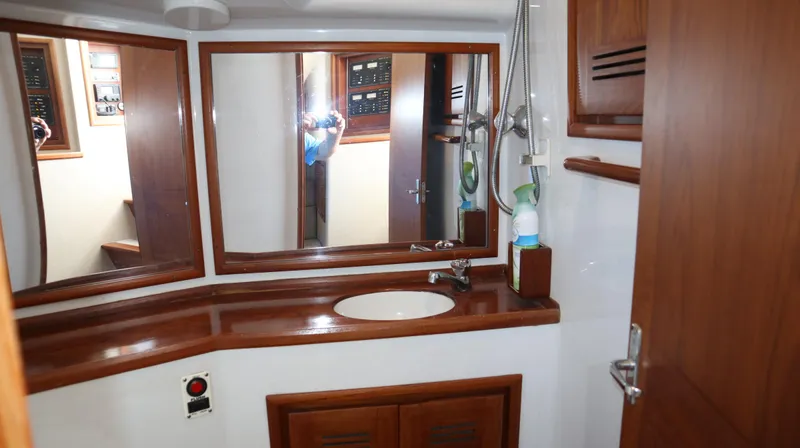 Lures & Liars Yacht Photos Pics 2002 Miller Marine Express bathroom with wooden cabinetry and large mirror.