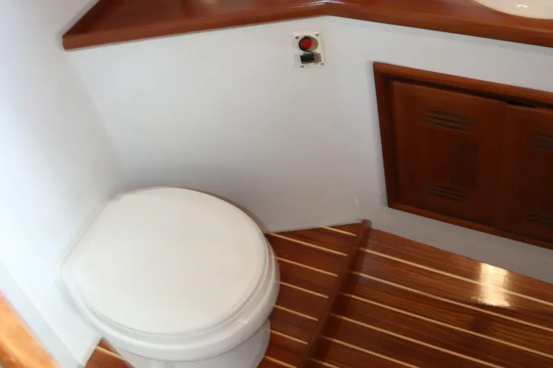 Lures & Liars Yacht Photos Pics 2002 Miller Marine Express boat bathroom with wooden flooring and compact toilet.