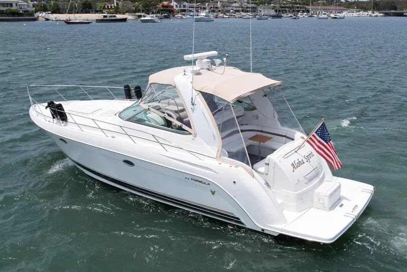 Aloha Spirit Yacht Photos Pics 2003 Formula 40 PC yacht cruising on water with American flag, marina in background.