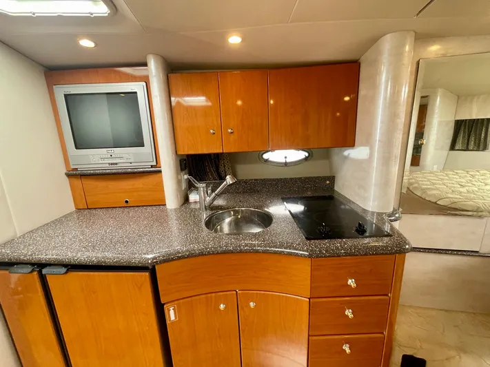 Aloha Spirit Yacht Photos Pics 2003 Formula 40 PC yacht kitchen with wood cabinets, sink, stove, and TV.