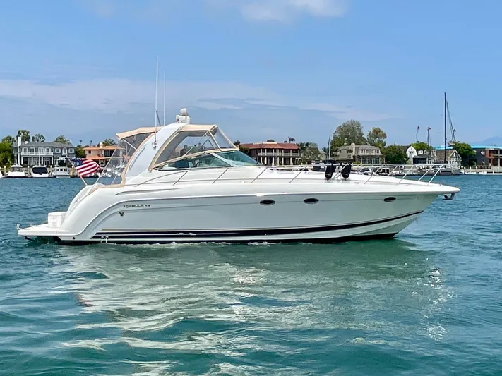 Aloha Spirit Yacht Photos Pics 2003 Formula 40 PC yacht cruising on a sunny day near waterfront homes.