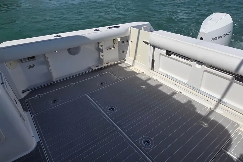  Yacht Photos Pics 2007 Boston Whaler 305 Conquest boat deck with Mercury engine, on calm water.