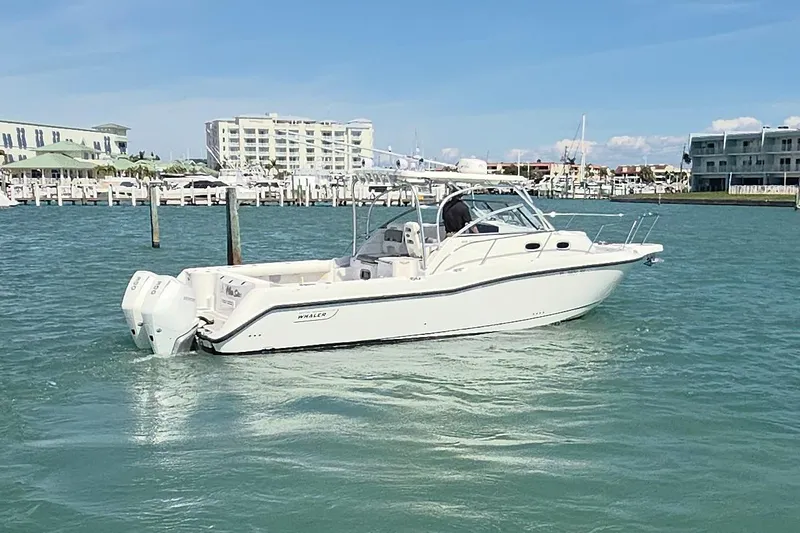  Yacht Photos Pics 2007 Boston Whaler 305 Conquest boat on water near marina, clear sky background.