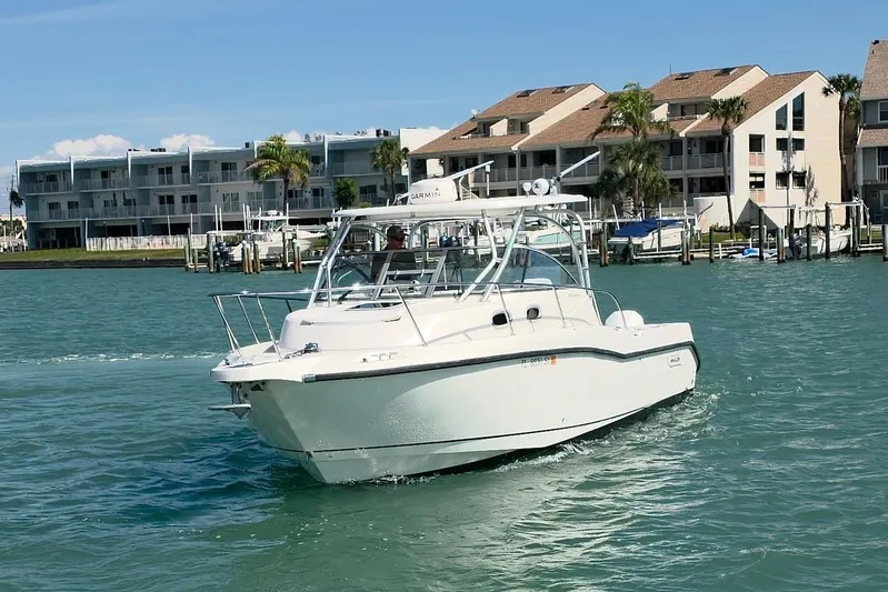  Yacht Photos Pics 2007 Boston Whaler 305 Conquest boat cruising near waterfront buildings.