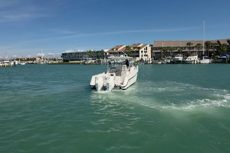  Yacht Photos Pics 2007 Boston Whaler 305 Conquest boat cruising in a marina with waterfront buildings.