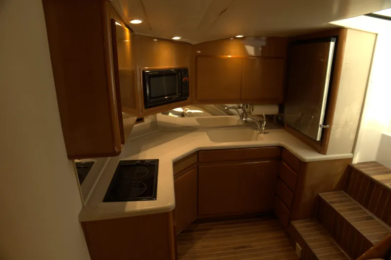 Blueprint Yacht Photos Pics 2002 Viking 43 Open yacht kitchen with wooden cabinets, stove, and microwave.