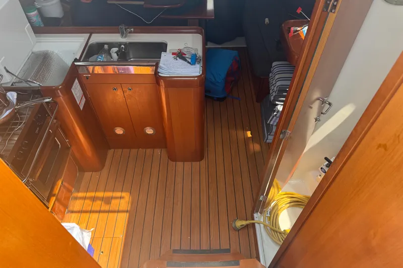  Yacht Photos Pics Interior of 2007 Beneteau Oceanis Clipper 373 yacht with wooden flooring and compact kitchen.