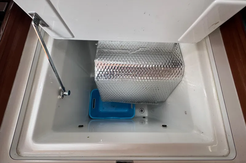  Yacht Photos Pics Open storage compartment in 2007 Beneteau Oceanis Clipper 373 yacht with insulation and blue tray.