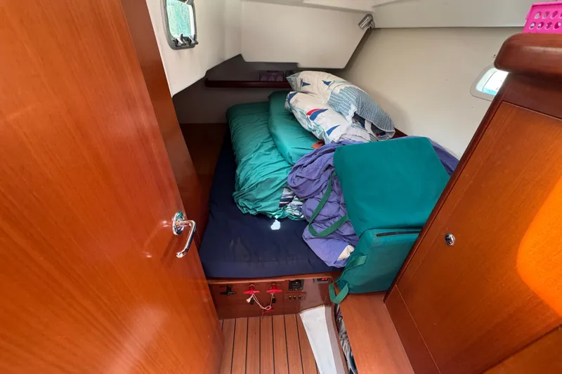  Yacht Photos Pics Cozy cabin interior of 2007 Beneteau Oceanis Clipper 373 sailboat with bedding and wooden finish.