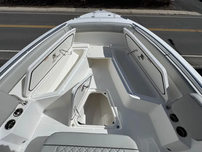  Yacht Photos Pics 2025 Pursuit S 268 boat with open storage compartments and seating area.