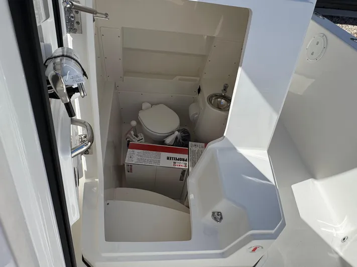  Yacht Photos Pics 2025 Pursuit S 268 boat interior with compact marine toilet and sink.