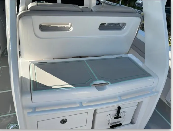  Yacht Photos Pics 2023 Intrepid 375 boat interior with storage compartment and cushioned seating.