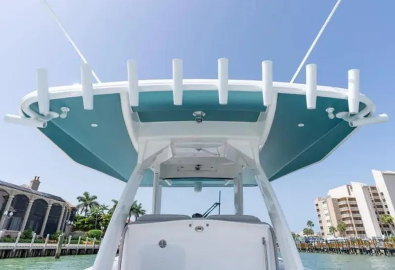  Yacht Photos Pics 2023 Intrepid 375 boat with sleek design, viewed from below, docked near waterfront buildings.