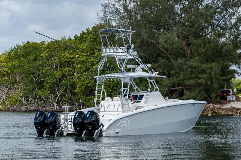  Yacht Photos Pics 2023 Prowler Renaissance 36 boat with triple outboard motors on a calm waterway.