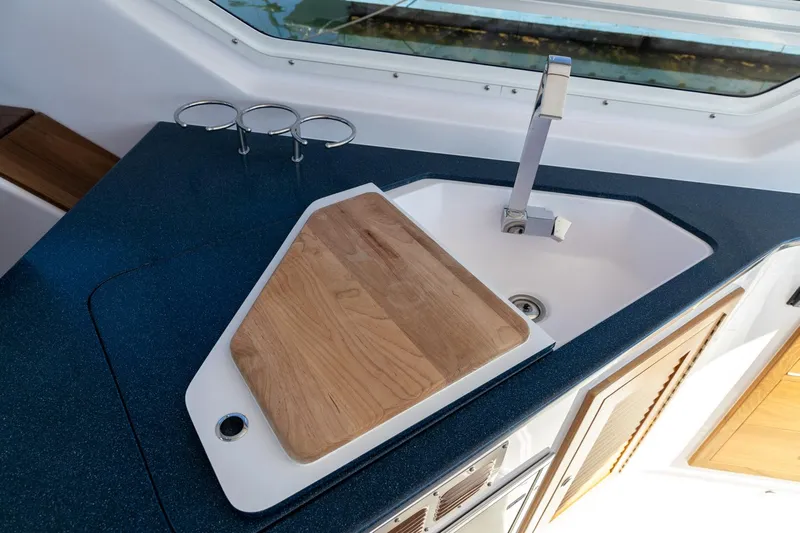 Dealer Demo Yacht Photos Pics Modern boat kitchen with sink, cutting board, and sleek countertop, True North 34, 2020 model.