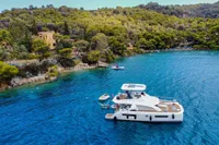 2020 Leopard 43 Powercat yacht anchored in a scenic, forested coastal bay.