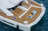 Woman relaxing on Leopard 43 Powercat yacht deck, 2020 model, in serene blue waters.