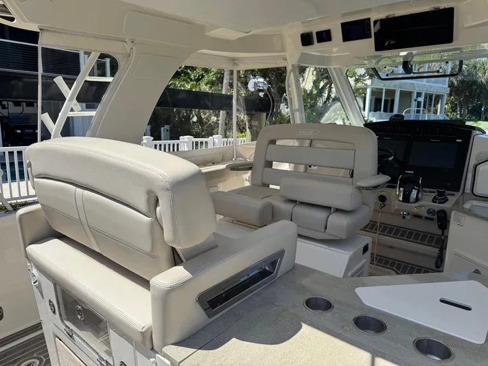  Yacht Photos Pics Interior of 2018 Boston Whaler 350 Realm boat with beige seating and modern controls.