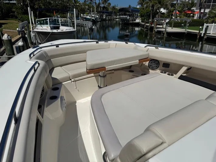  Yacht Photos Pics 2018 Boston Whaler 350 Realm boat interior with seating and table, docked in a marina.