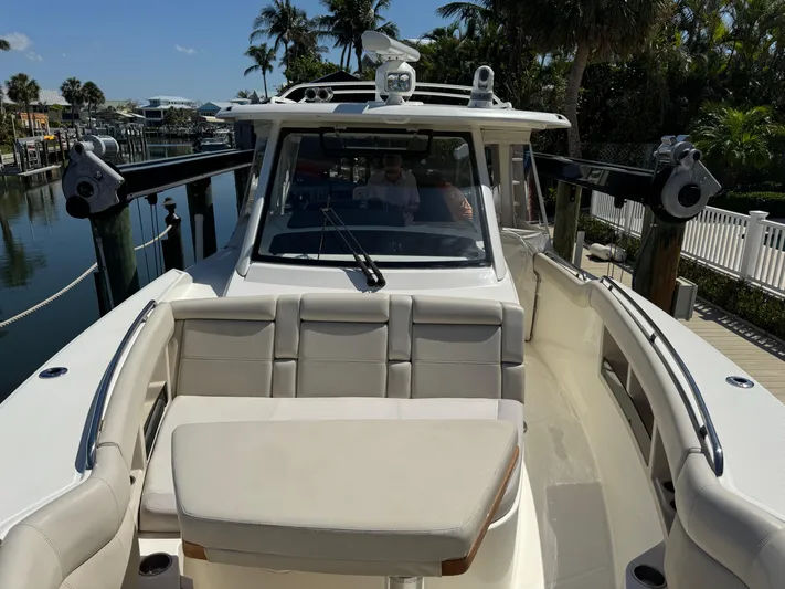  Yacht Photos Pics 2018 Boston Whaler 350 Realm boat docked, featuring spacious seating and modern design.