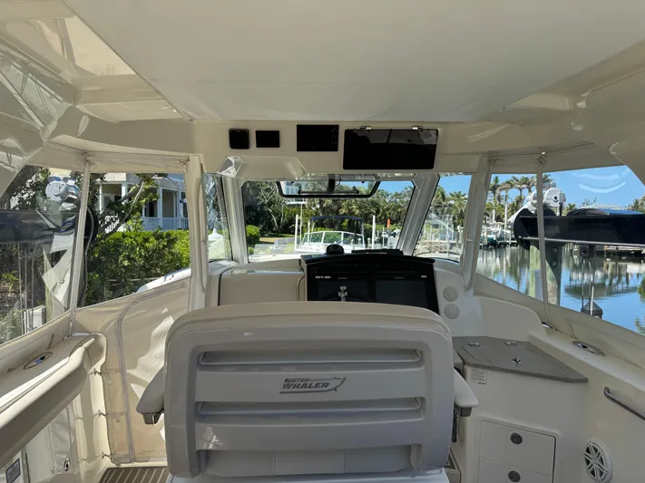 Yacht Photos Pics Interior view of 2018 Boston Whaler 350 Realm boat, featuring helm and seating area.