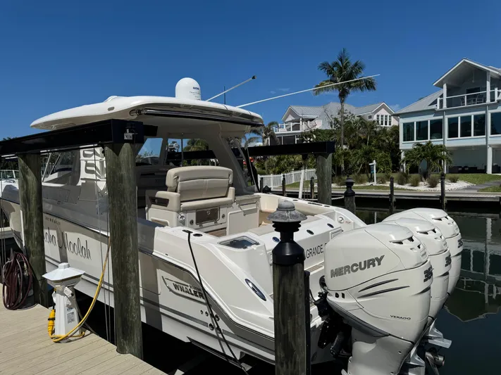  Yacht Photos Pics 2018 Boston Whaler 350 Realm docked, featuring triple Mercury engines, in a sunny marina setting.