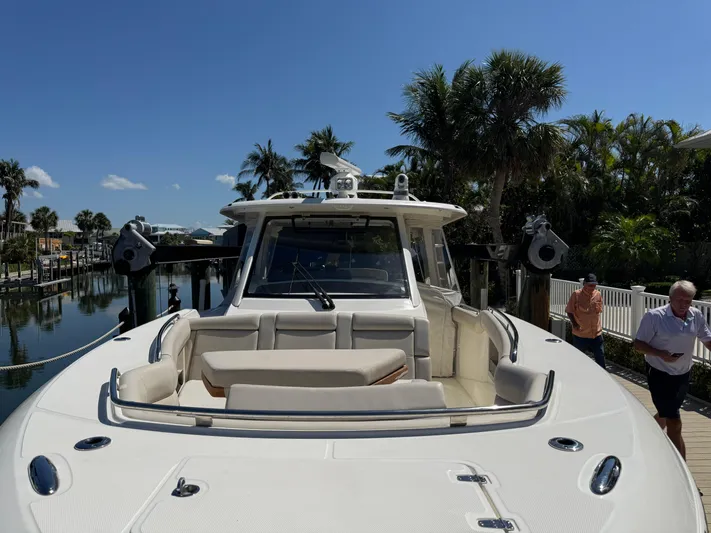  Yacht Photos Pics 2018 Boston Whaler 350 Realm boat docked, surrounded by palm trees and clear blue sky.