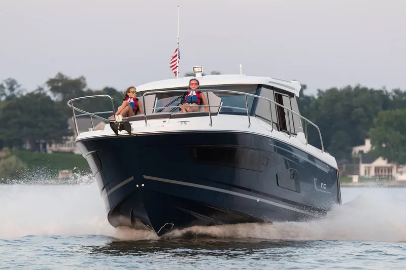  Yacht Photos Pics Manufacturer Provided Image: 2020 Jeanneau NC 1095 motorboat cruising on water with passengers.