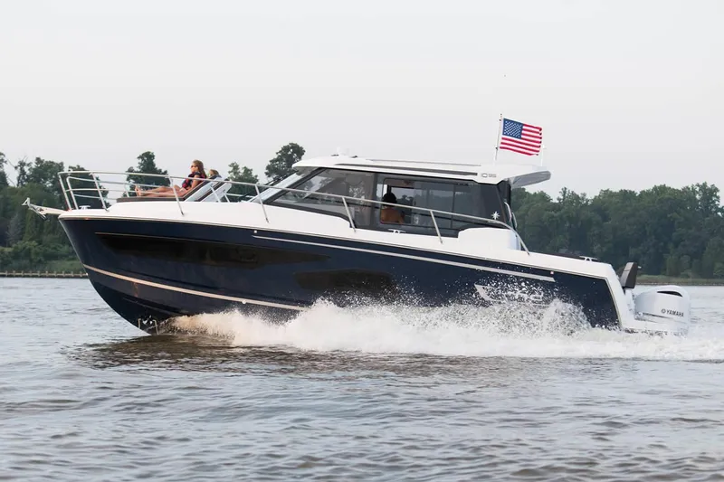 Yacht Photos Pics Manufacturer Provided Image: 2020 Jeanneau NC 1095 motorboat cruising on a lake with American flag.