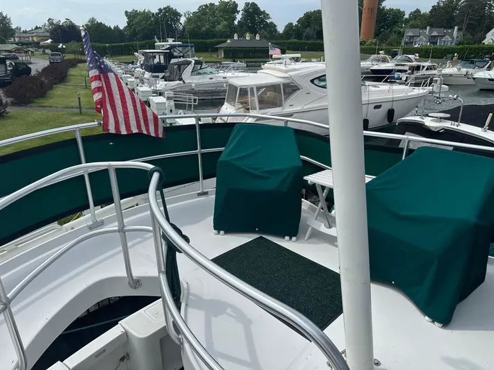 River Miss Yacht Photos Pics 1997 Mainship 350 yacht deck with green covers and American flag in marina.