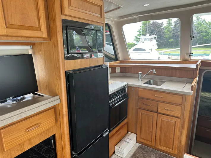 River Miss Yacht Photos Pics Interior of a 1997 Mainship 350 yacht featuring a compact kitchen with wood cabinetry.