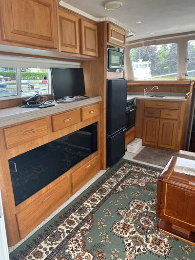 River Miss Yacht Photos Pics Interior of 1997 Mainship 350 yacht with kitchen, cabinets, and carpeted floor.