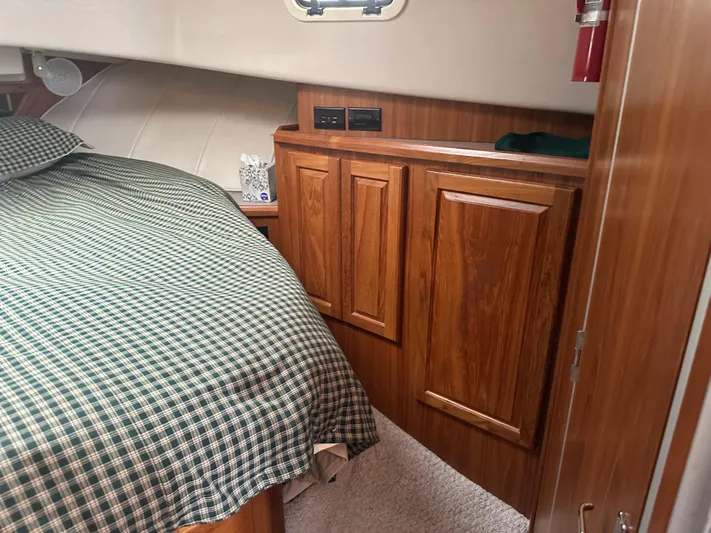 River Miss Yacht Photos Pics 1997 Mainship 350 cabin interior with wood cabinets and checkered bedding.