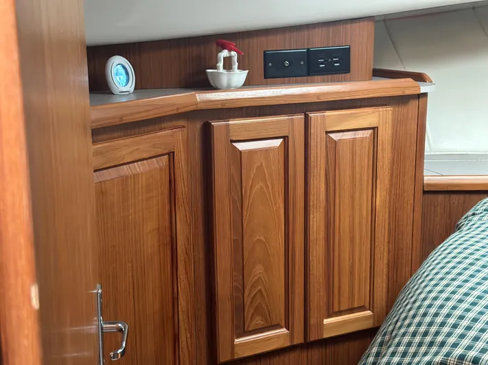 River Miss Yacht Photos Pics Wooden cabinetry in 1997 Mainship 350 boat interior with clock and electrical outlet.