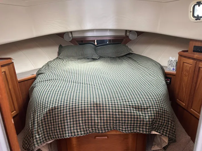 River Miss Yacht Photos Pics 1997 Mainship 350 cabin interior with a cozy bed and wooden cabinetry.