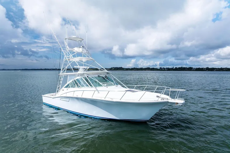 Pescador Yacht Photos Pics 2004 Cabo 40 Hardtop Express yacht on calm waters under cloudy sky.