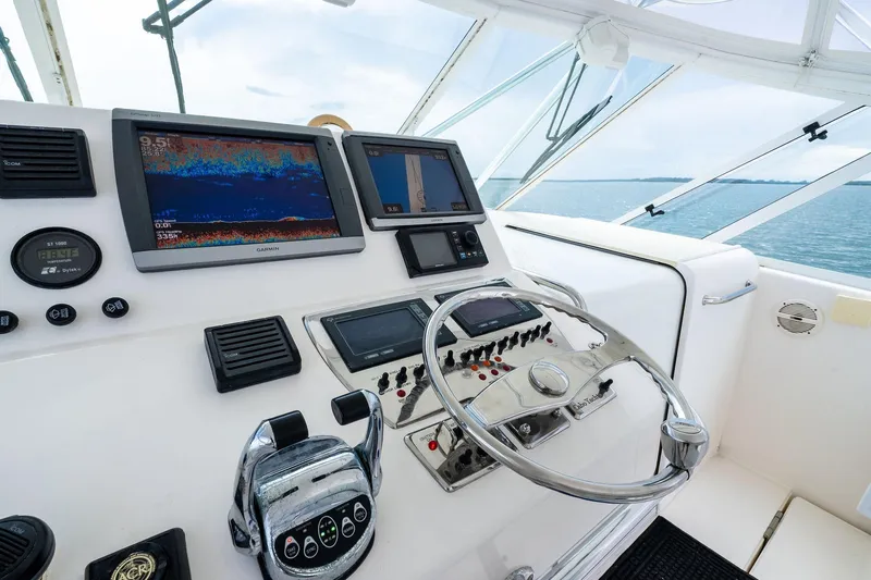 Pescador Yacht Photos Pics Helm of 2004 Cabo 40 Hardtop Express with navigation screens and steering wheel.