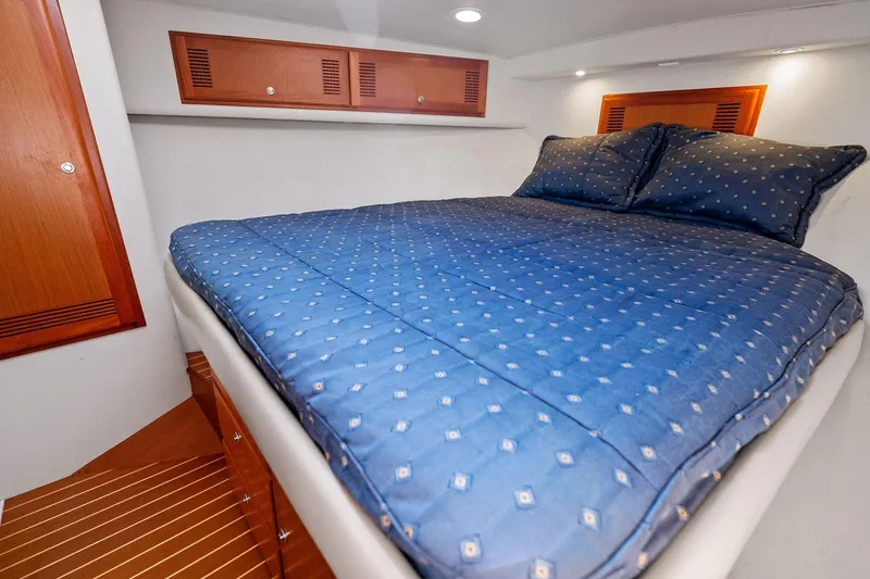 Pescador Yacht Photos Pics Luxurious cabin interior of 2004 Cabo 40 Hardtop Express with cozy bed and wooden accents.