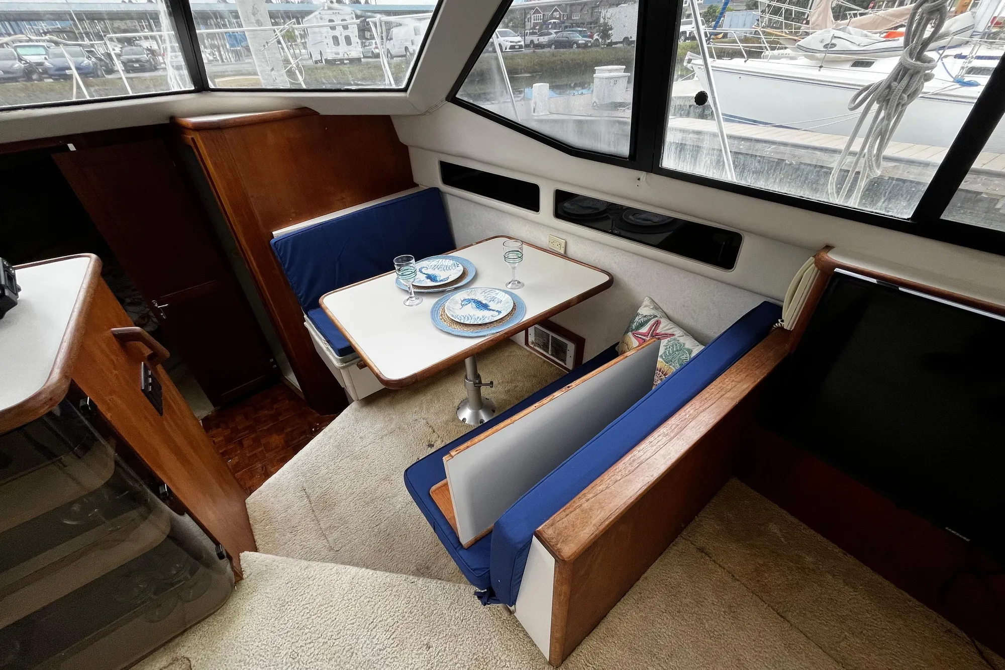 Interior of 1991 Carver 33 Aft Cabin Motor Yacht with dining area and blue seating.