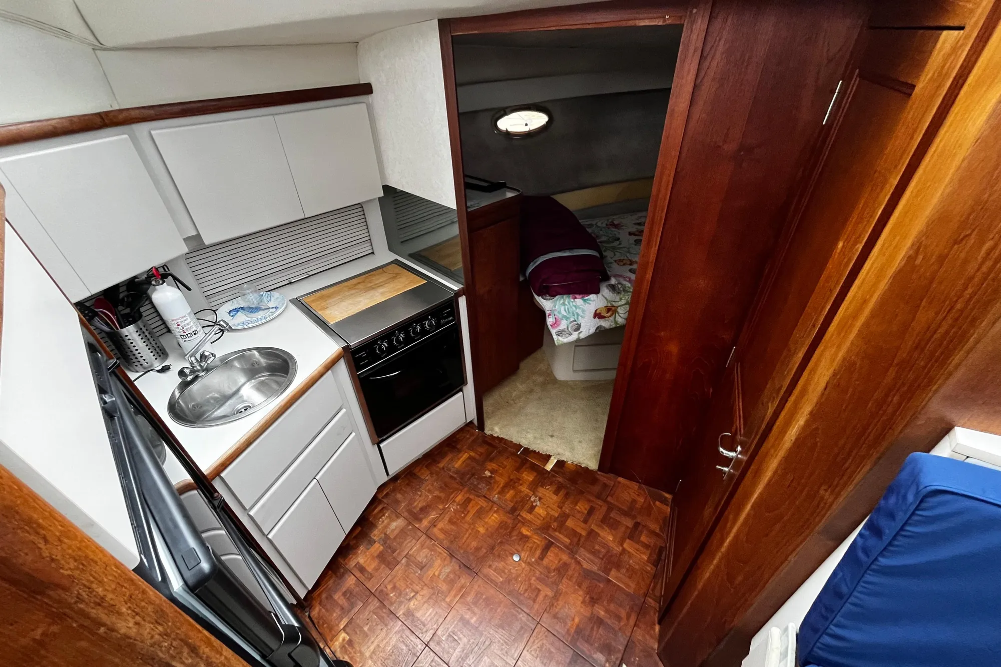 Interior of 1991 Carver 33 Aft Cabin Motor Yacht with kitchen and cozy bedroom.