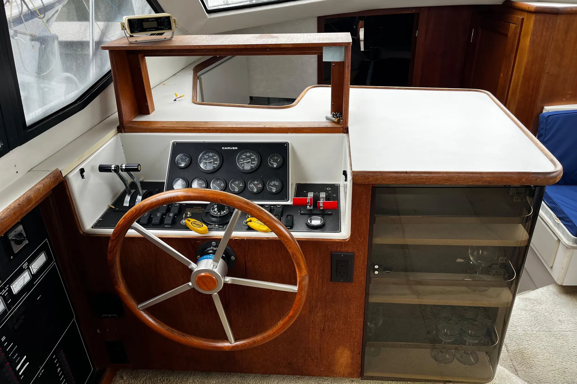 1991 Carver 33 Aft Cabin Motor Yacht helm with wooden steering wheel and control panel.