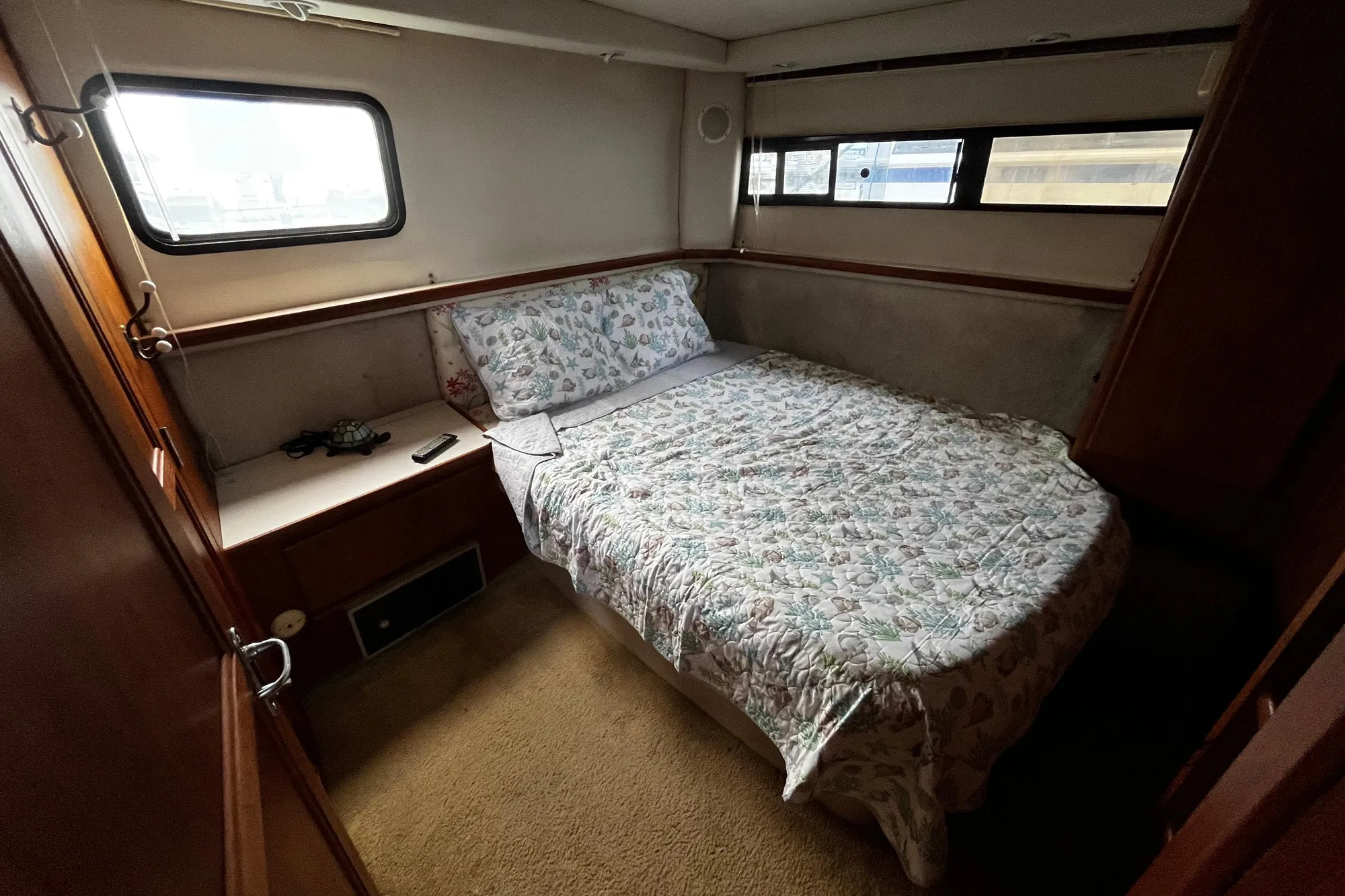 Cozy bedroom in 1991 Carver 33 Aft Cabin Motor Yacht with floral bedding.