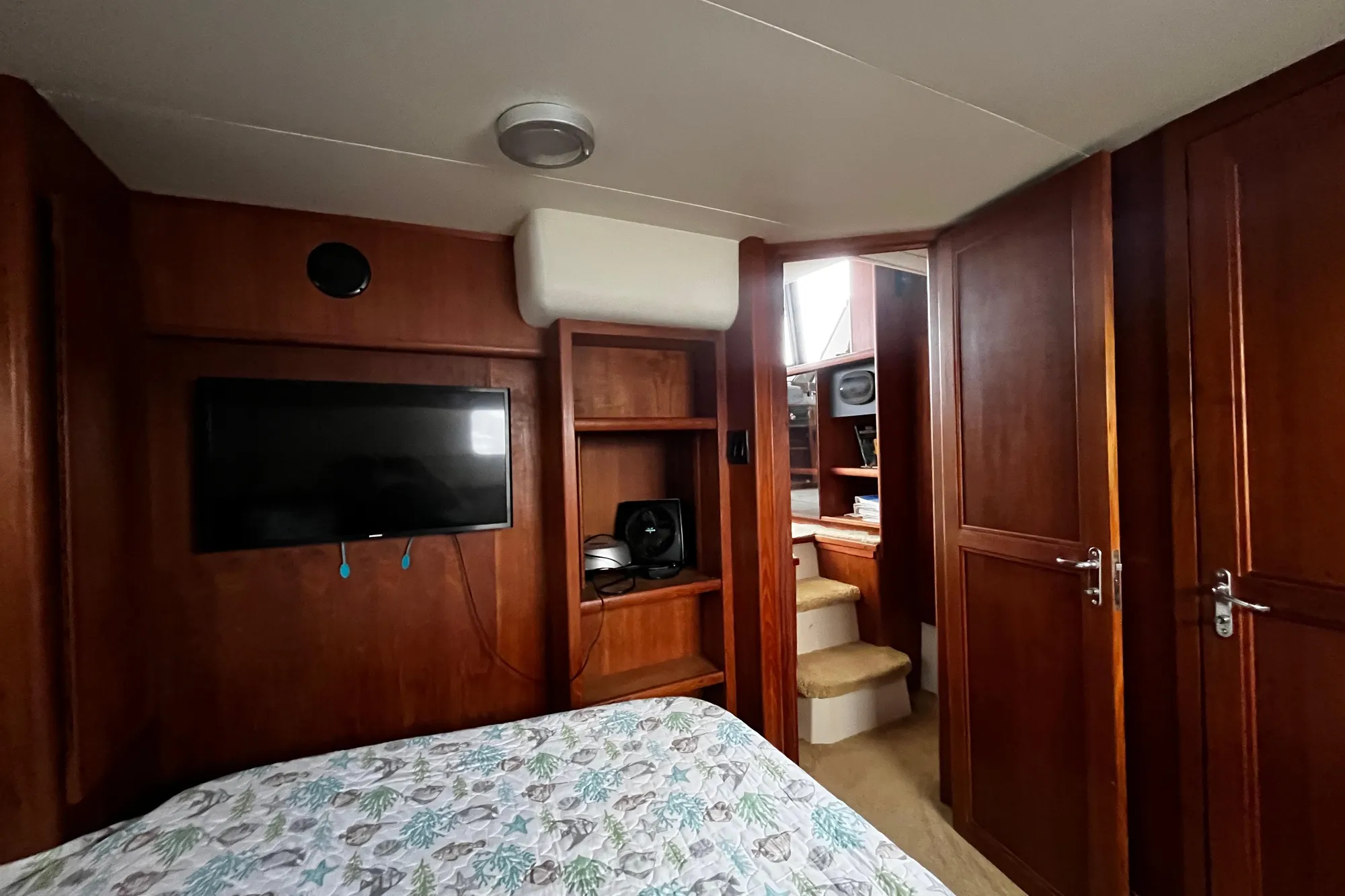 Interior of 1991 Carver 33 Aft Cabin Motor Yacht with wood paneling and TV.