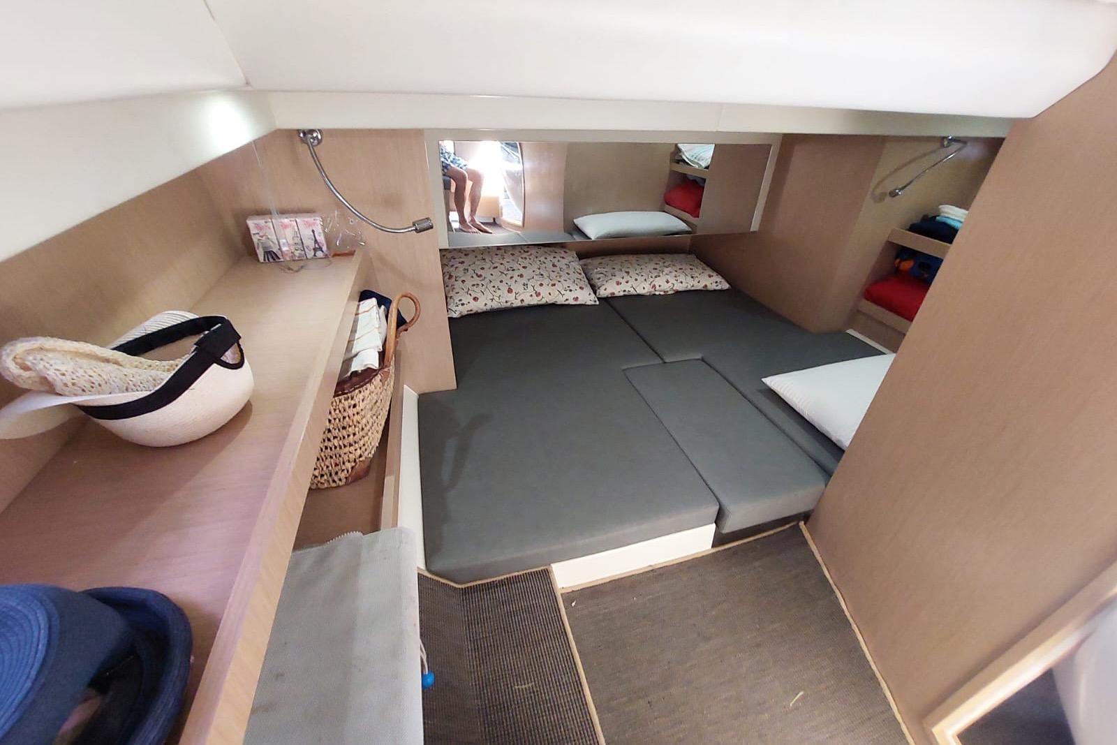 Cozy cabin interior of 2017 Need Yacht 32 with bed and storage shelves.