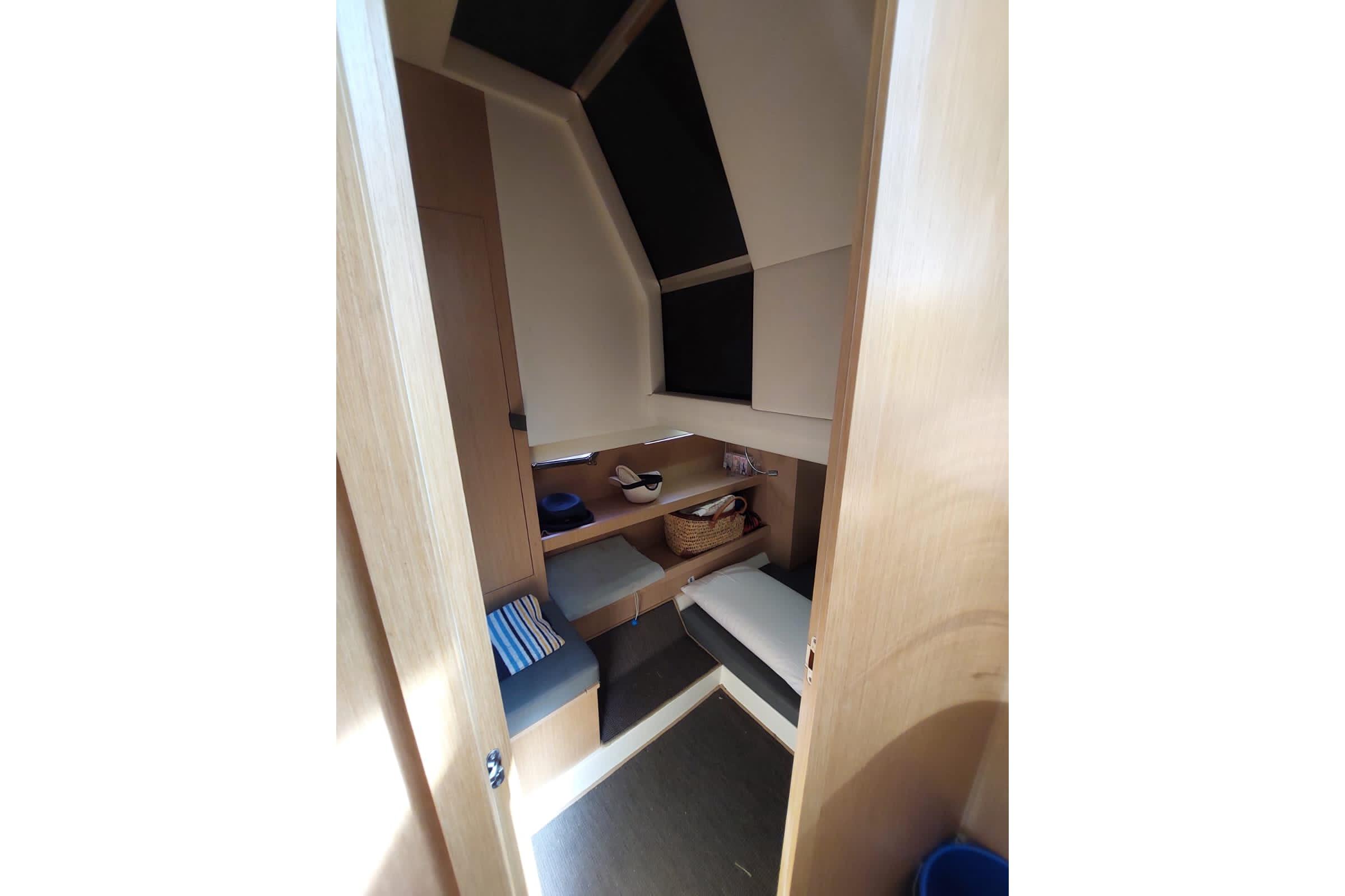 Interior cabin of 2017 Need Yacht 32, featuring cozy seating and storage.