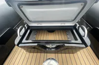 Open storage compartment on 2022 Ribeye A811 boat with wooden deck.