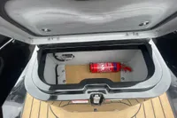 Open storage compartment in Ribeye A811 boat with fire extinguisher inside.